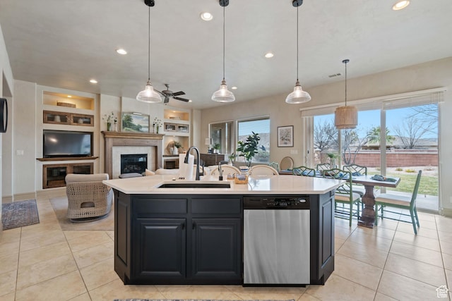 2653 Rio Lobo Dr, St George, UT 84770 - kitchen with light tile patterned flooring, light countertops, a sink, a glass covered fireplace, and stainless steel dishwasher