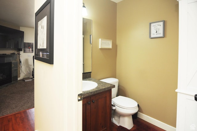 245 E 660 S, Willard, UT 84340 - half bath with vanity, toilet, baseboards, wood finished floors, and a tile fireplace