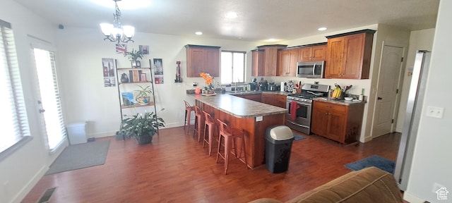 245 E 660 S, Willard, UT 84340 - kitchen with a peninsula, a breakfast bar, dark wood finished floors, a notable chandelier, and stainless steel appliances