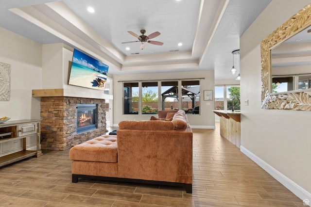 714 N Millcreek Springs Dr, Washington, UT 84780 - living area featuring a tray ceiling, wood tiled floors, healthy amount of natural light, a fireplace, and recessed lighting