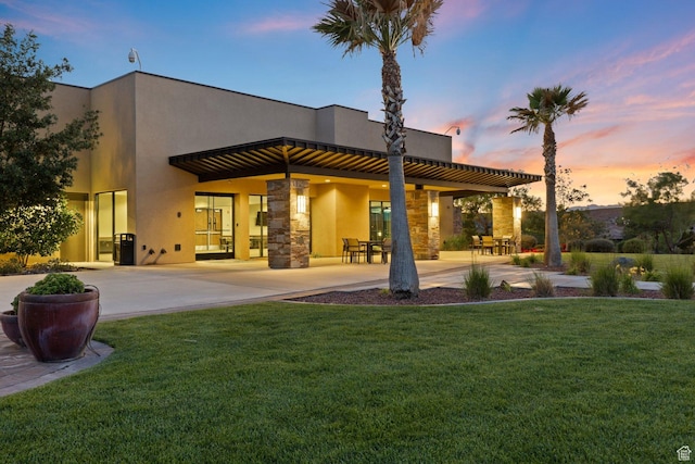714 N Millcreek Springs Dr, Washington, UT 84780 - back of property featuring stucco siding, a lawn, a patio, and stone siding