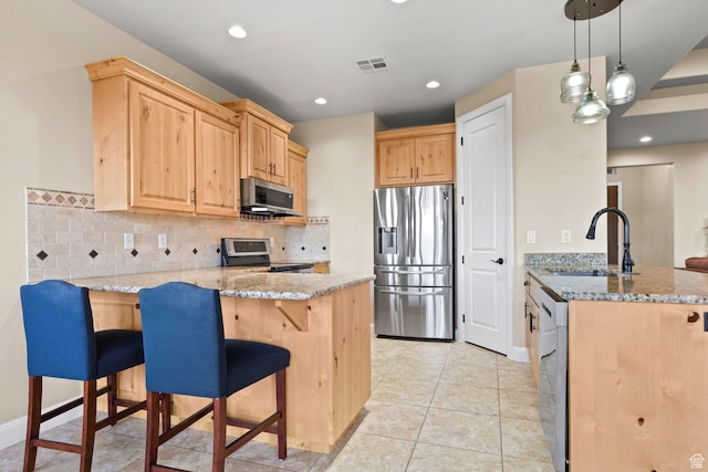 714 N Millcreek Springs Dr, Washington, UT 84780 - kitchen with stainless steel appliances, a peninsula, light brown cabinets, a sink, and light stone countertops