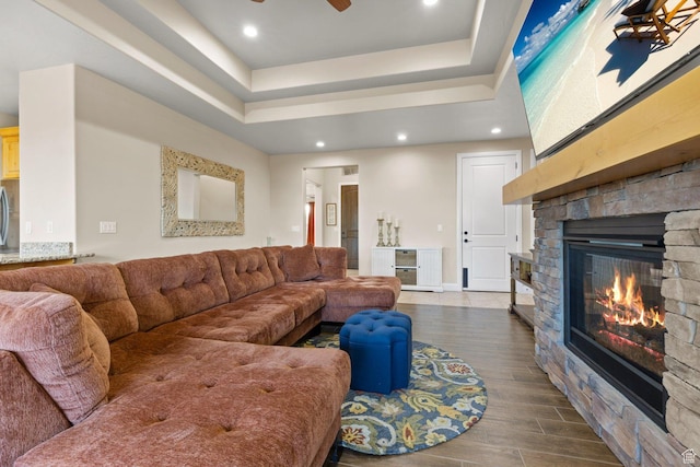 714 N Millcreek Springs Dr, Washington, UT 84780 - living area with a stone fireplace, a raised ceiling, dark wood-type flooring, ceiling fan, and recessed lighting
