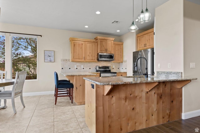 714 N Millcreek Springs Dr, Washington, UT 84780 - kitchen with stainless steel appliances, baseboards, light brown cabinets, light stone countertops, and recessed lighting