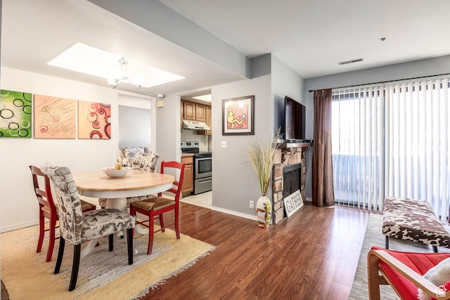 6861 N 2200 W Unit 9D, Park City, UT 84098 - dining space featuring light wood-style flooring, visible vents, baseboards, a fireplace, and a notable chandelier