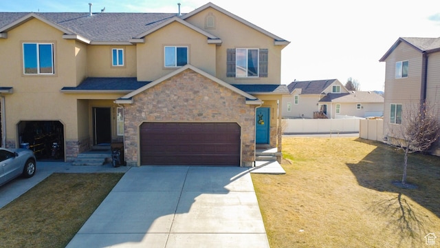 view of front facade featuring stone siding, an attached garage, and stucco siding