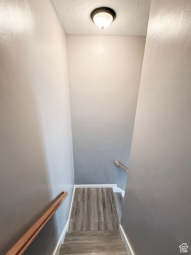 2016 E Cedar Trails Way, Eagle Mountain, UT 84005 - stairway featuring a textured ceiling, wood finished floors, and baseboards