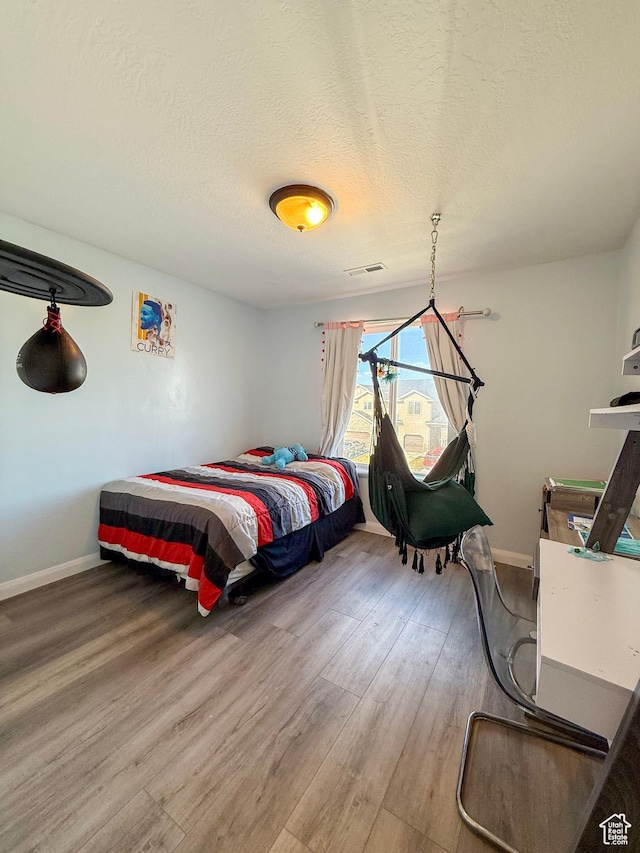 2016 E Cedar Trails Way, Eagle Mountain, UT 84005 - bedroom featuring wood finished floors, a textured ceiling, and baseboards