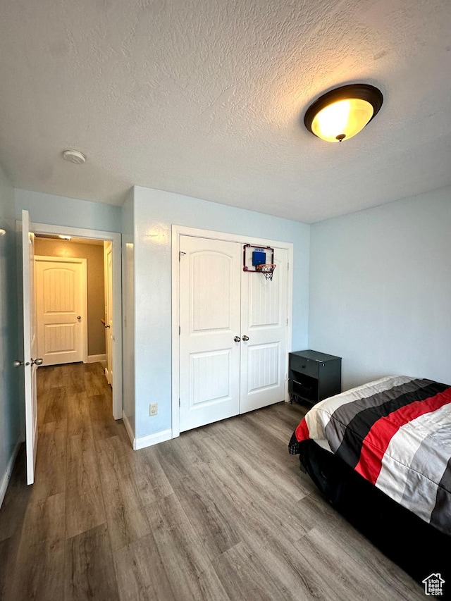 2016 E Cedar Trails Way, Eagle Mountain, UT 84005 - bedroom with wood finished floors, a textured ceiling, baseboards, and a closet