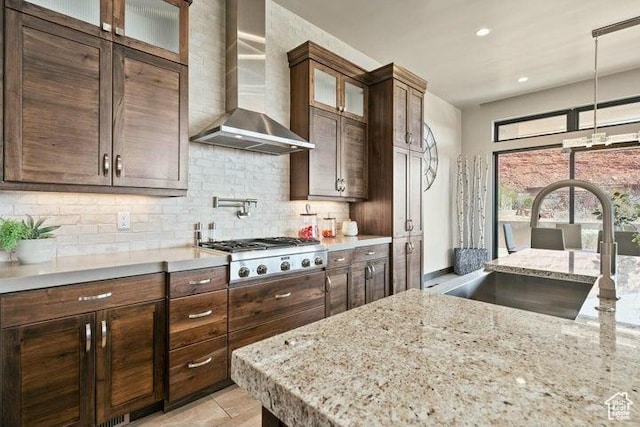 3052 N Snow Canyon Pkwy Unit 36, St George, UT 84770 - kitchen featuring stainless steel gas cooktop, wall chimney exhaust hood, dark brown cabinets, tasteful backsplash, and a sink
