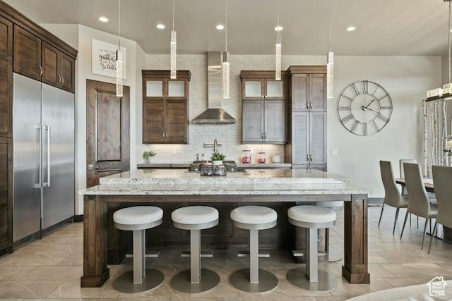 3052 N Snow Canyon Pkwy Unit 36, St George, UT 84770 - kitchen featuring stainless steel built in fridge, a breakfast bar area, a spacious island, backsplash, and wall chimney exhaust hood