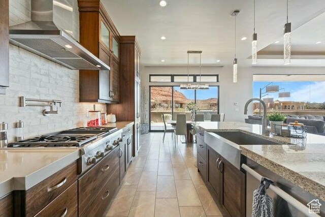 3052 N Snow Canyon Pkwy Unit 36, St George, UT 84770 - kitchen featuring decorative backsplash, hanging light fixtures, a sink, appliances with stainless steel finishes, and wall chimney exhaust hood