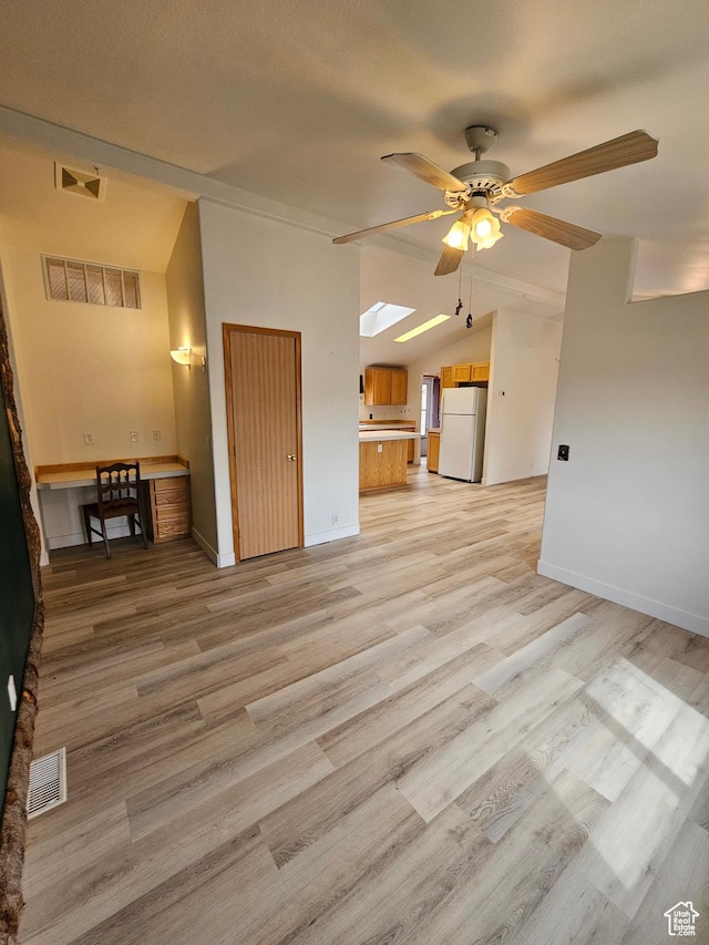 2350 S Red Creek Rd, Fruitland, UT 84027 - unfurnished living room with visible vents, a ceiling fan, and vaulted ceiling with skylight