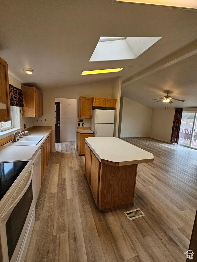 2350 S Red Creek Rd, Fruitland, UT 84027 - kitchen featuring lofted ceiling with skylight, white appliances, brown cabinets, a sink, and a center island