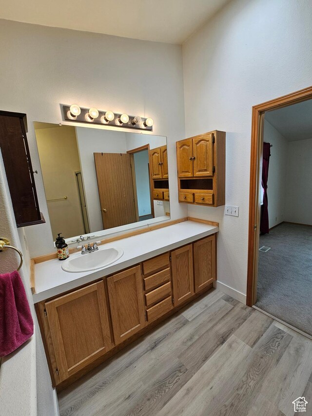 2350 S Red Creek Rd, Fruitland, UT 84027 - bathroom with high vaulted ceiling, visible vents, baseboards, wood finished floors, and vanity