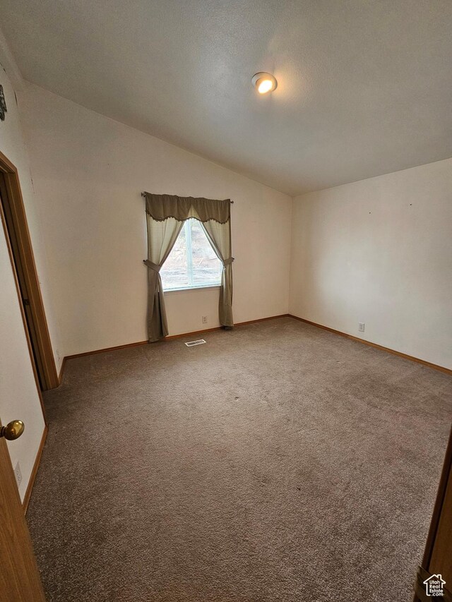 2350 S Red Creek Rd, Fruitland, UT 84027 - empty room featuring vaulted ceiling, carpet flooring, baseboards, a textured ceiling, and visible vents