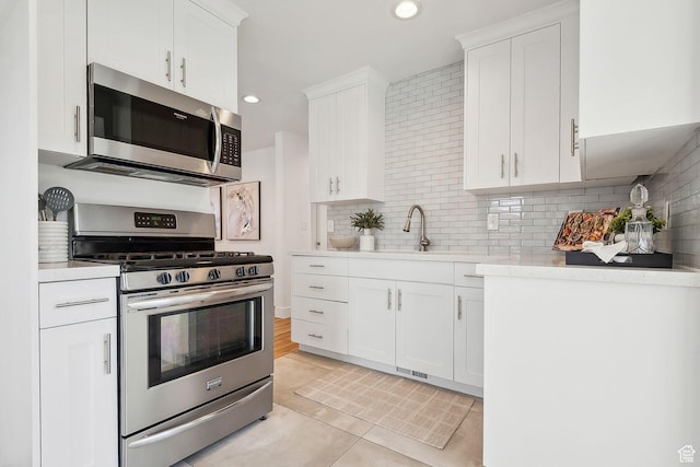 1138 E Hudson Ave, Salt Lake City, UT 84106 - kitchen with decorative backsplash, light countertops, a sink, and appliances with stainless steel finishes