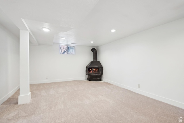 1138 E Hudson Ave, Salt Lake City, UT 84106 - below grade area featuring baseboards, a wood stove, recessed lighting, and light carpet