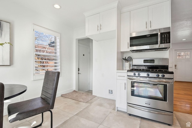 1138 E Hudson Ave, Salt Lake City, UT 84106 - kitchen with white cabinets, stainless steel appliances, a healthy amount of sunlight, and light tile patterned floors