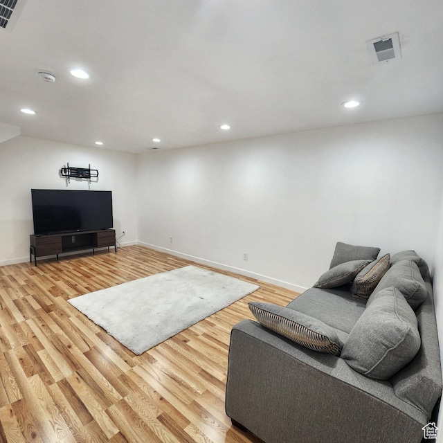 living area featuring baseboards, visible vents, light wood-style flooring, and recessed lighting