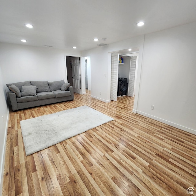 unfurnished living room with baseboards, washer / clothes dryer, recessed lighting, and light wood-type flooring