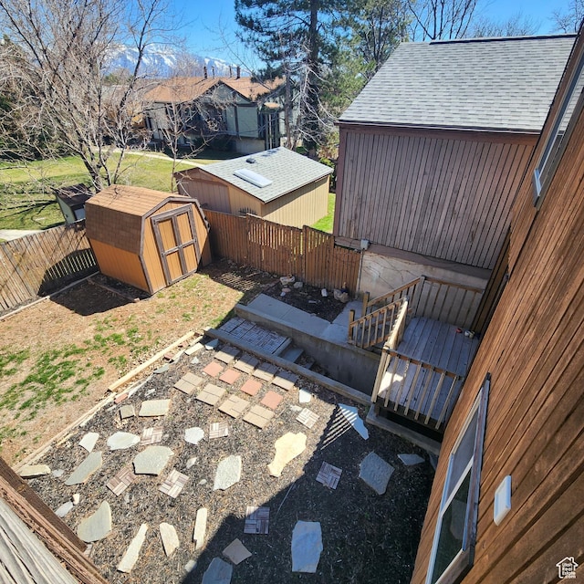view of patio with an outbuilding, a fenced backyard, and a storage shed