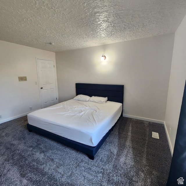 bedroom with baseboards, a textured ceiling, and carpet