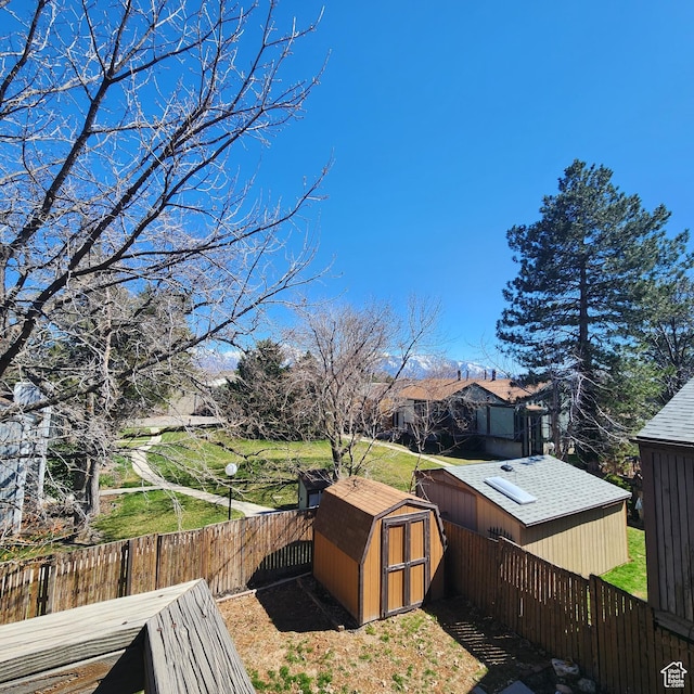 view of yard featuring a fenced backyard, an outdoor structure, and a shed