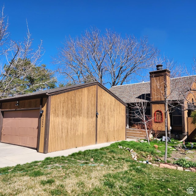 view of outbuilding featuring an attached garage and concrete driveway