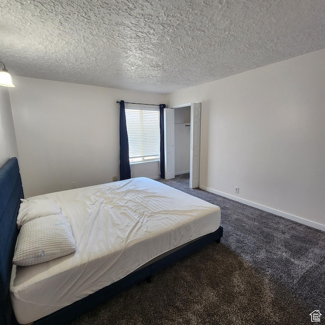 carpeted bedroom featuring baseboards, a closet, and a textured ceiling