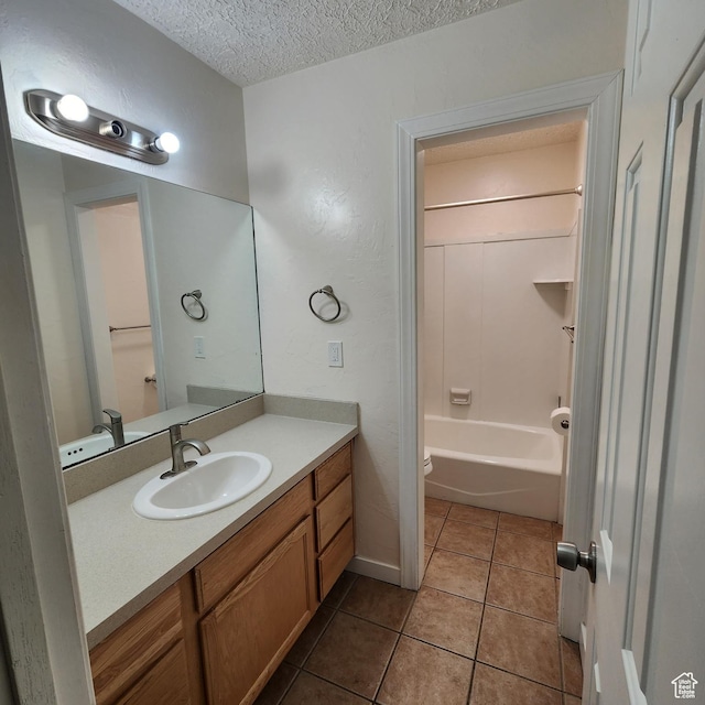 bathroom with a textured ceiling, toilet, vanity, shower / washtub combination, and tile patterned flooring