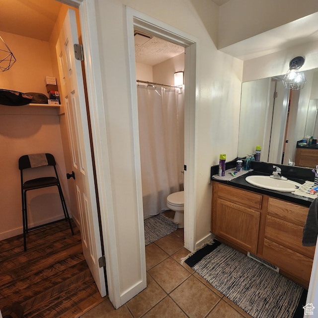 bathroom with tile patterned flooring, vanity, toilet, a shower with shower curtain, and a textured ceiling