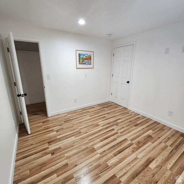 spare room with light wood finished floors, baseboards, and recessed lighting