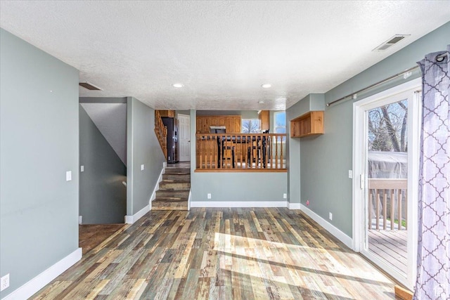 100 Crayon Ct, Logan, UT 84321 - interior space featuring a textured ceiling, visible vents, wood finished floors, baseboards, and stairs