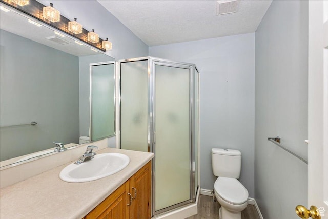 100 Crayon Ct, Logan, UT 84321 - bathroom featuring visible vents, a shower stall, wood finished floors, vanity, and toilet