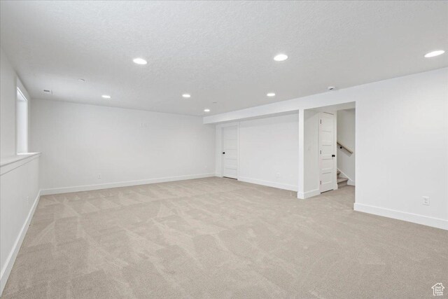 2230 S 635 W Unit B, Perry, UT 84302 - finished below grade area with stairs, a textured ceiling, light colored carpet, and recessed lighting