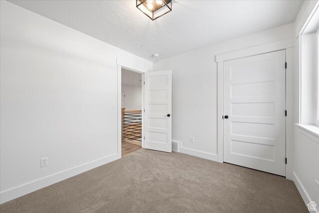 2230 S 635 W Unit B, Perry, UT 84302 - unfurnished bedroom featuring baseboards, carpet floors, a textured ceiling, and a closet