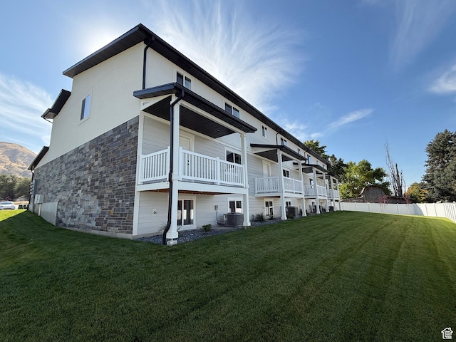 2230 S 635 W Unit B, Perry, UT 84302 - rear view of house featuring stone siding, central AC, and a yard