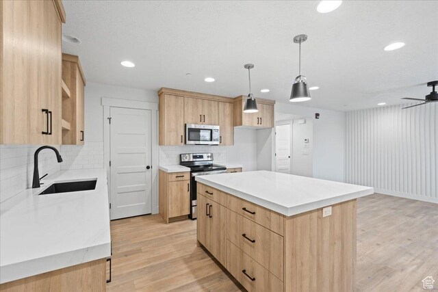 2230 S 635 W Unit B, Perry, UT 84302 - kitchen with light countertops, a sink, appliances with stainless steel finishes, light brown cabinets, and light wood-style floors