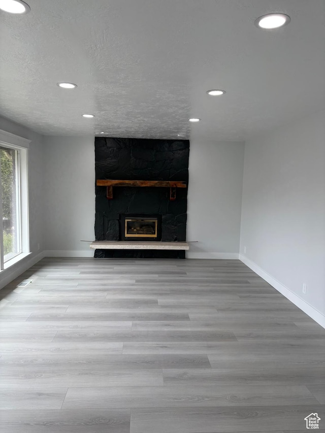 1406 Swinton Ln, Farmington, UT 84025 - unfurnished living room with wood finished floors, baseboards, a stone fireplace, and recessed lighting