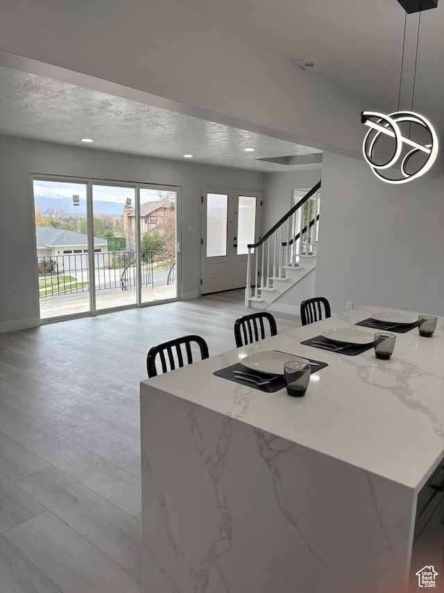1406 Swinton Ln, Farmington, UT 84025 - dining space featuring baseboards, light wood finished floors, a notable chandelier, and stairs