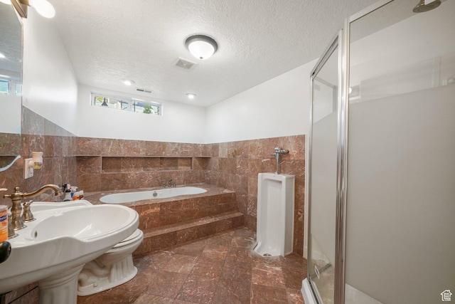 3429 W Picabo St S, Taylorsville, UT 84129 - bathroom with tile walls, a stall shower, a bath, a textured ceiling, and toilet