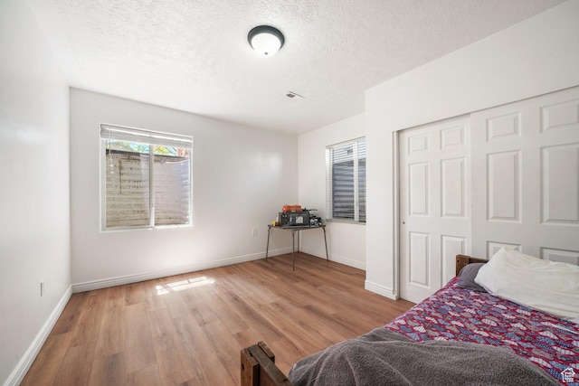 3429 W Picabo St S, Taylorsville, UT 84129 - bedroom featuring wood finished floors, a textured ceiling, baseboards, and a closet