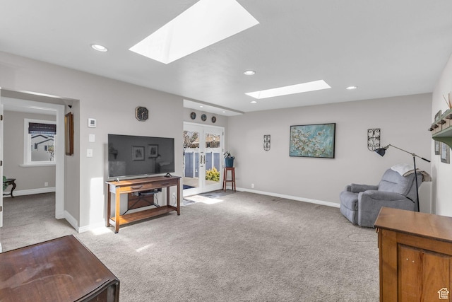 living room with baseboards, french doors, a skylight, and light colored carpet
