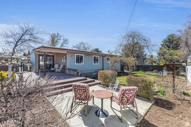 rear view of property with a deck, fence, and a patio area