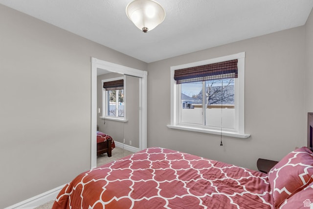 bedroom with baseboards and carpet