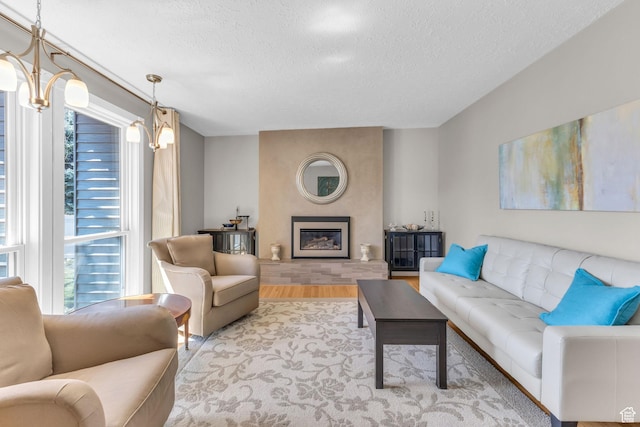 living area featuring a fireplace, wood finished floors, and a textured ceiling