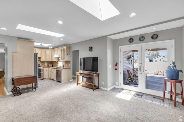 living room with french doors, a skylight, and light colored carpet