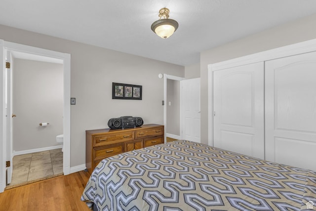 bedroom featuring a closet, baseboards, and wood finished floors