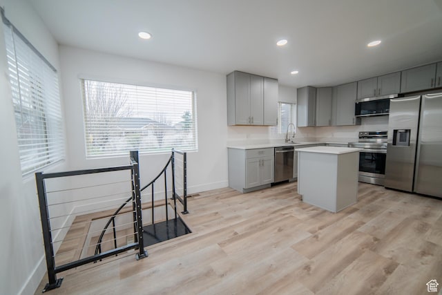 627 W La Salle Dr, Murray, UT 84123 - kitchen with a center island, gray cabinetry, light wood-style flooring, and appliances with stainless steel finishes
